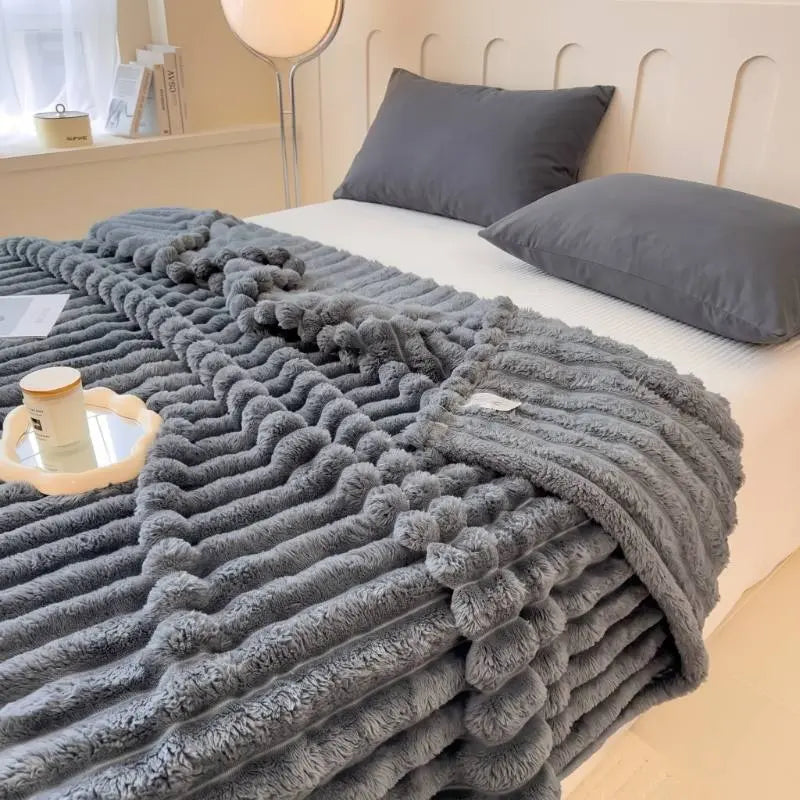 Plaid Softly. gris moelleux en fleece posé sur un lit, texture 3D douce et cocooning